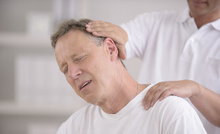 Muž s osteochondrózou krku na konzultácii s manuálnym masérom